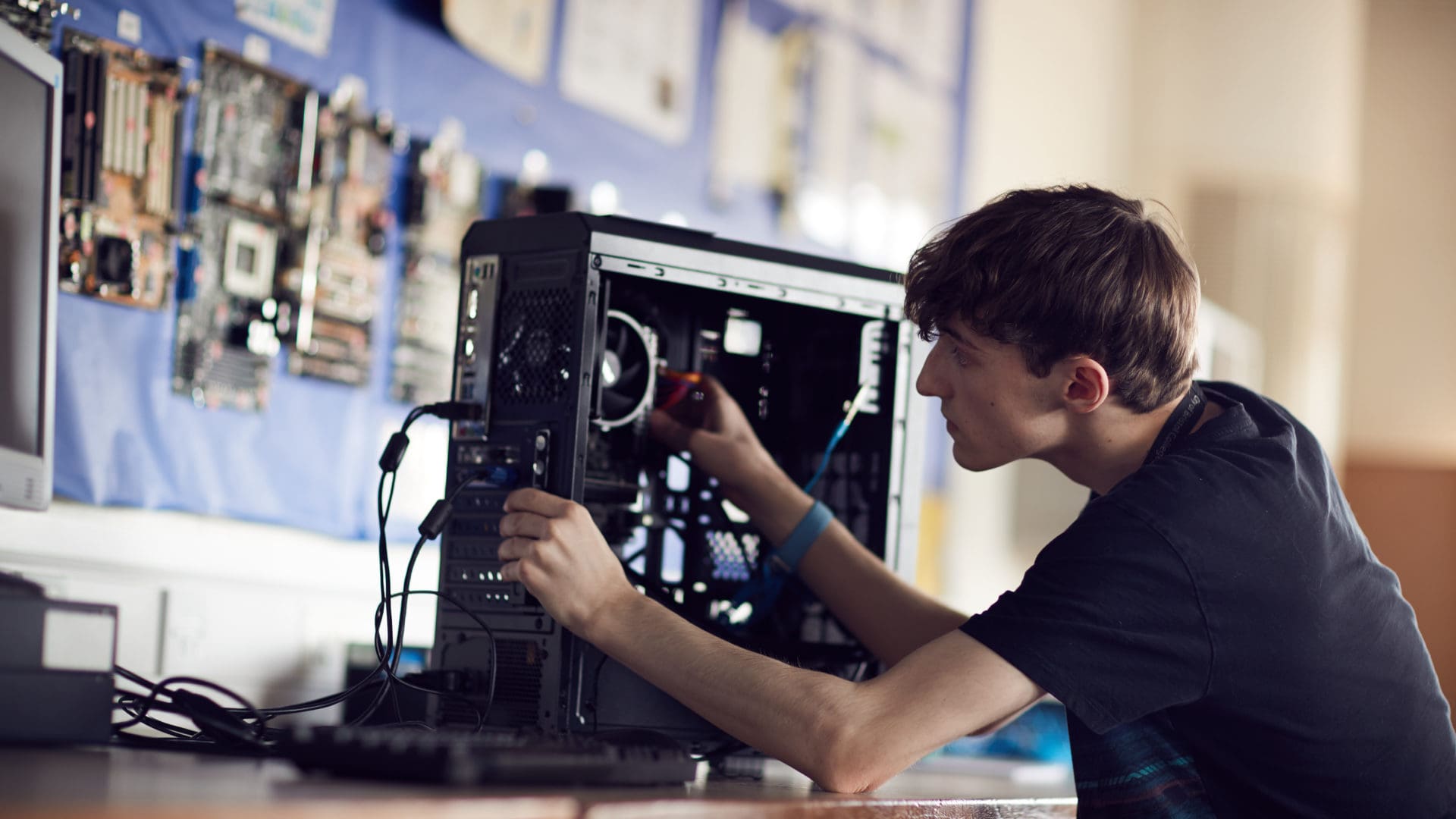 糖心vlog会员 student focusing on fixing a computer on an IT course